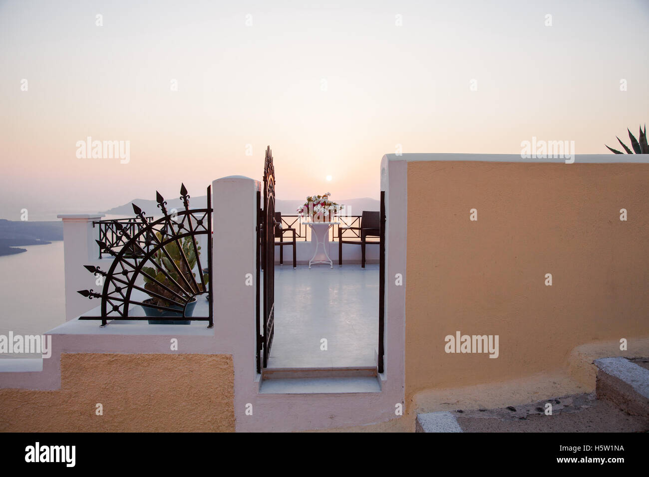 Une vue sur une porte menant à un patio et ci-dessous, c'est la mer et un magnifique coucher de soleil Banque D'Images