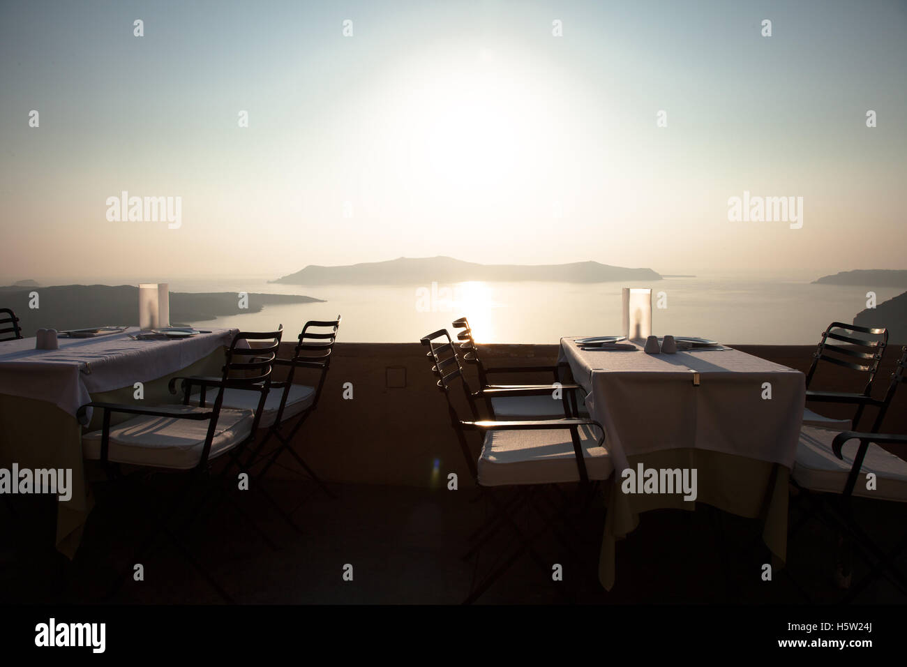 Un restaurant avec des tables donnant sur la mer et les îles dans le coucher du soleil. Banque D'Images
