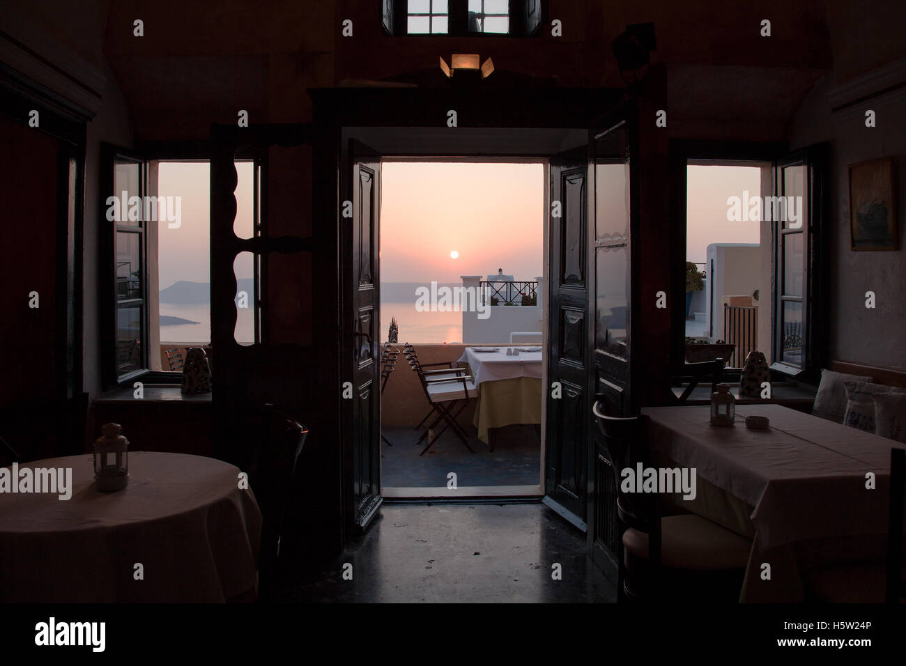 Un restaurant avec des tables donnant sur la mer et les îles dans le coucher du soleil. Banque D'Images