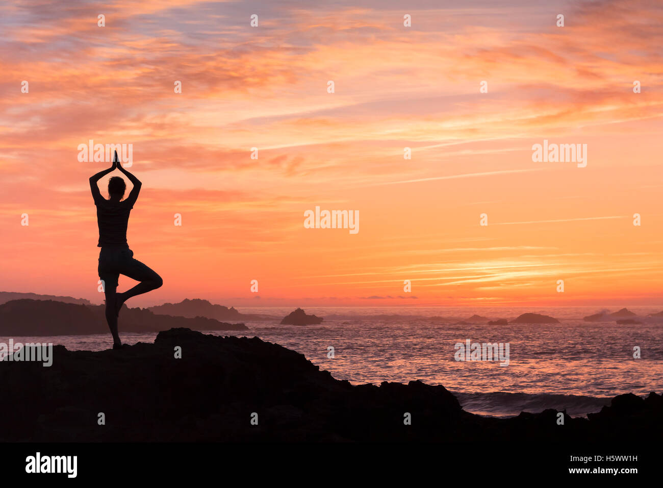 Femme qui se bat avec anxiété le yoga près de la mer Banque D'Images