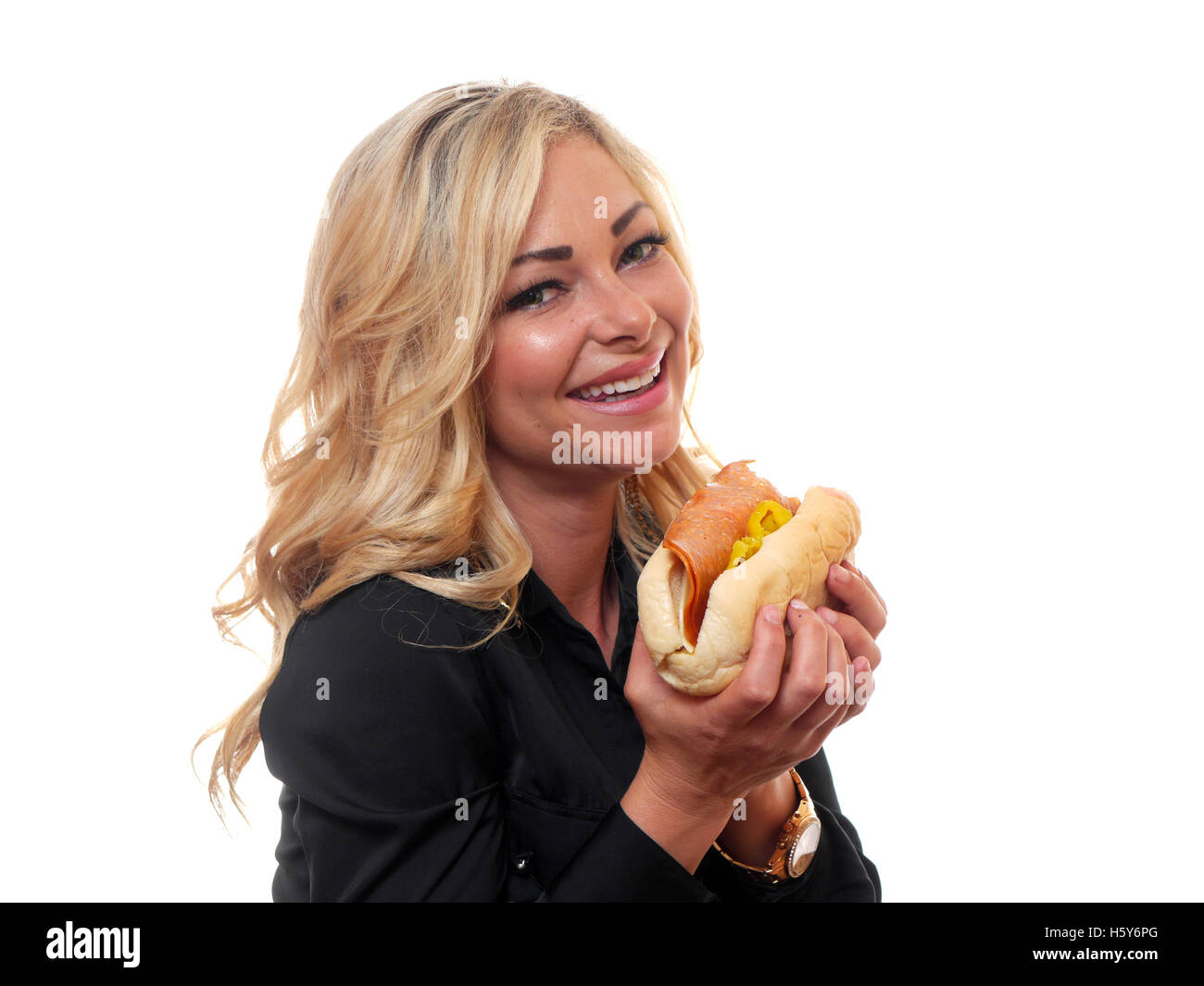 Une jolie femme est en train de manger un sandwich de style déli. Banque D'Images