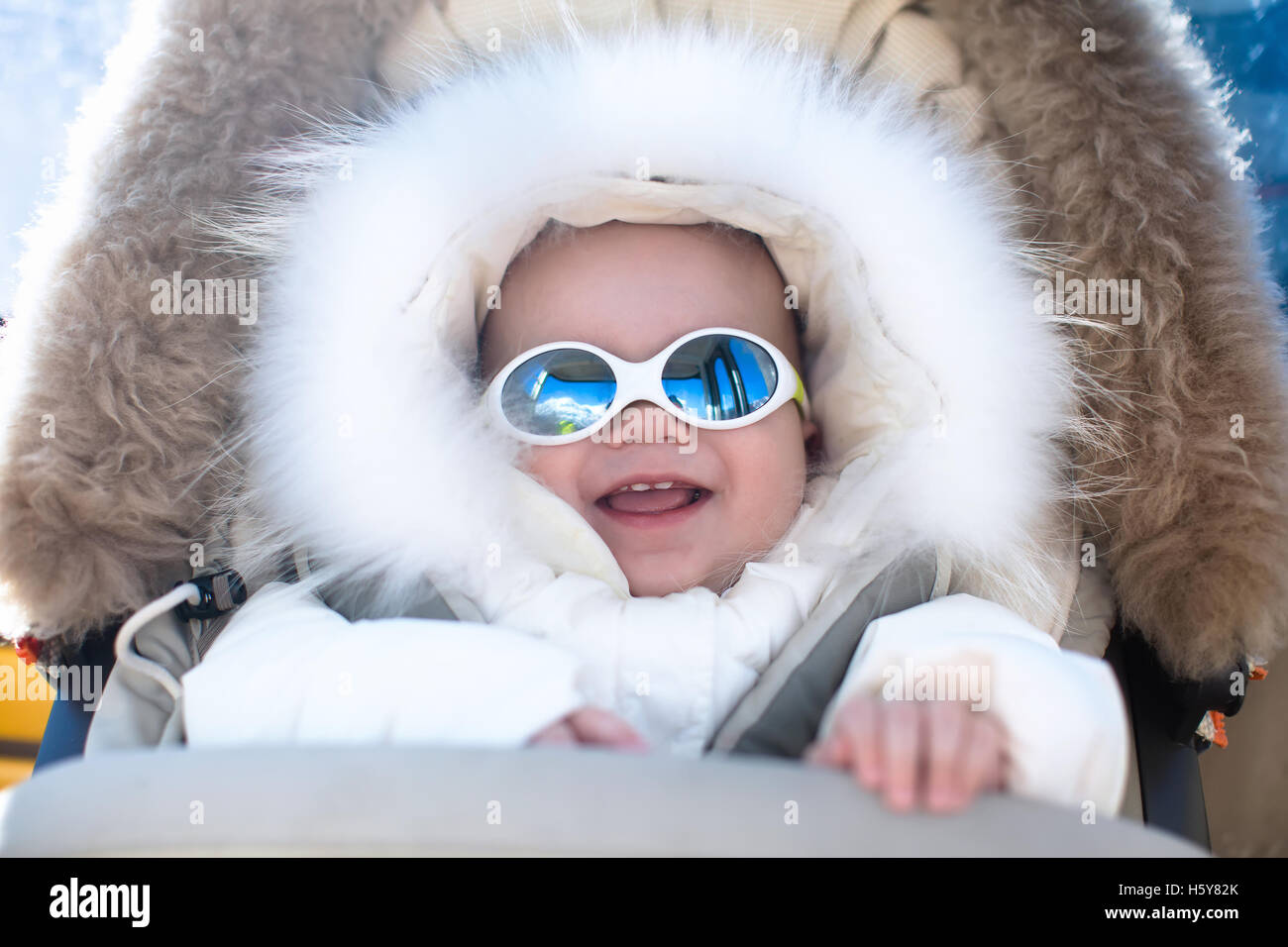 Petit bébé dans la poussette chaude fourrure habineige capot bénéficiant  d'hiver ski vacances en station de ski. Lunettes de soleil pour enfants  Photo Stock - Alamy
