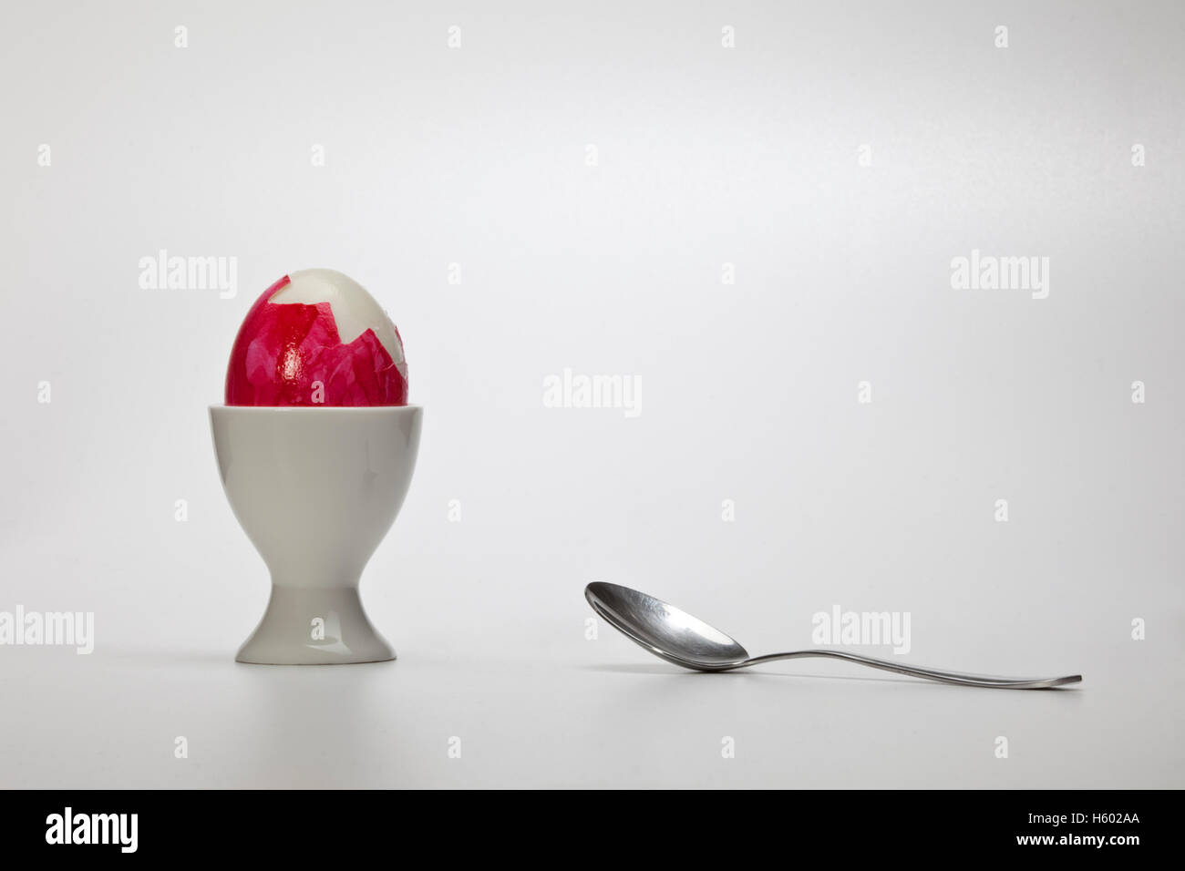 Oeuf de Pâques dans une tasse d'oeufs avec une cuillère en argent Banque D'Images