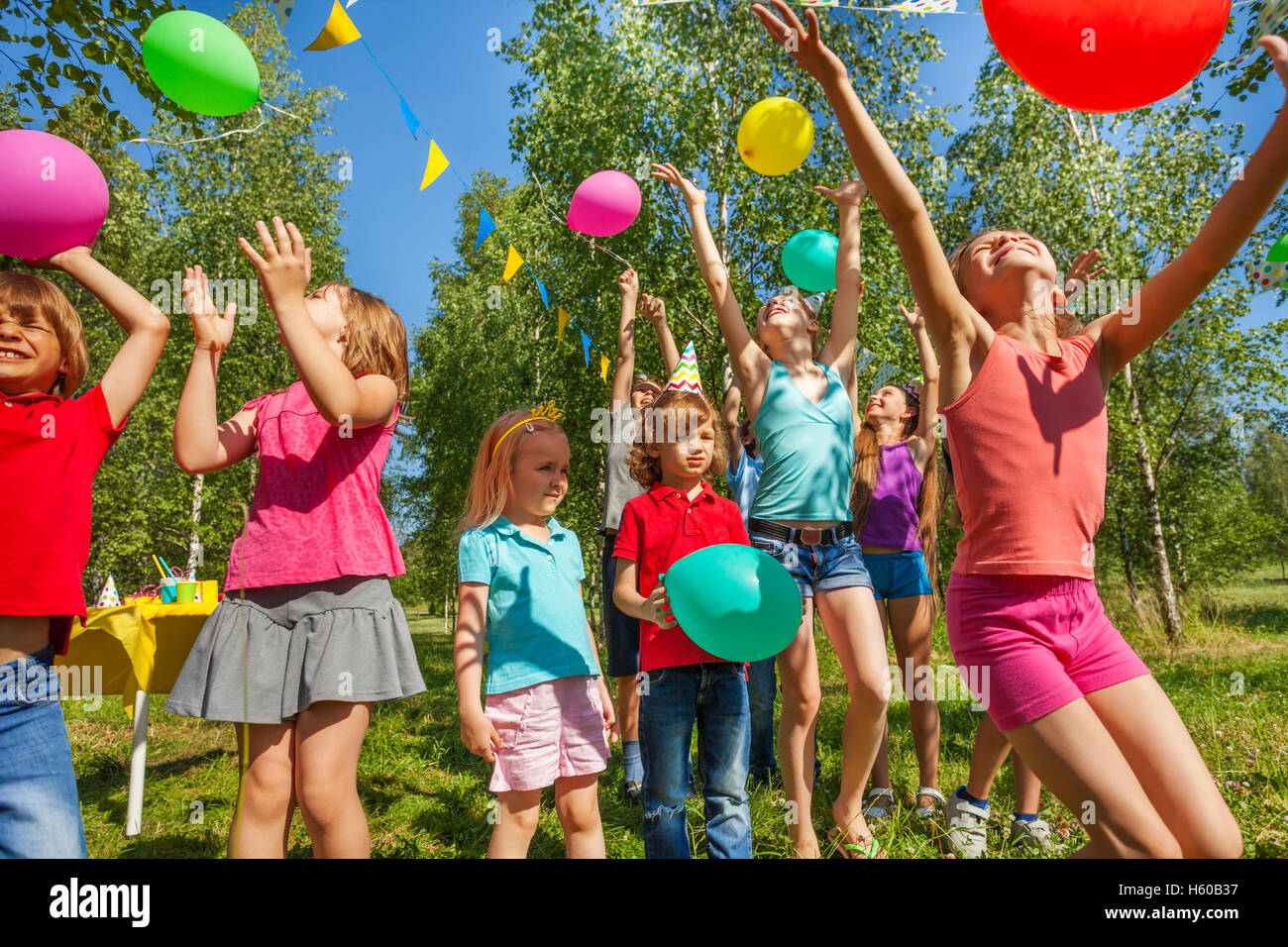 Heureux les enfants jouant et attraper des ballons colorés Banque D'Images
