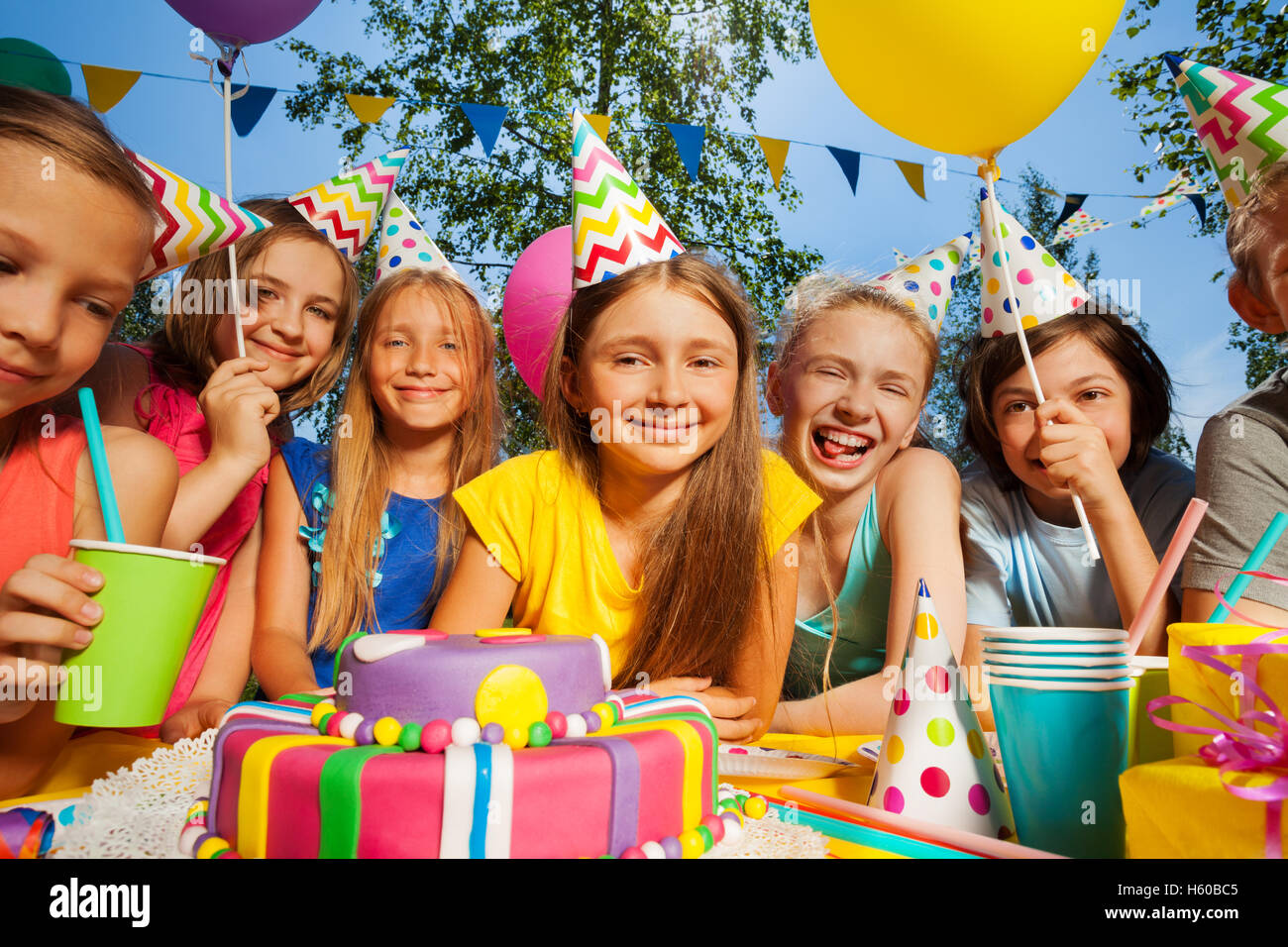 Grand groupe d'enfants souriants autour du gâteau d'anniversaire Banque D'Images