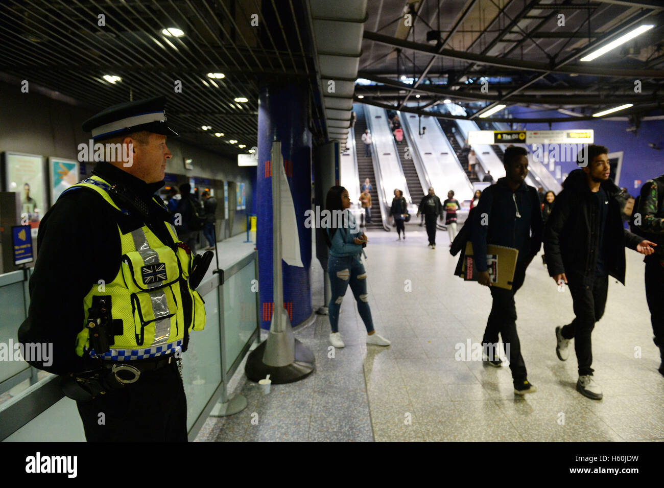 Un agent de police se tient dans le hall d'entrée de la station de métro North Greenwich. Banque D'Images