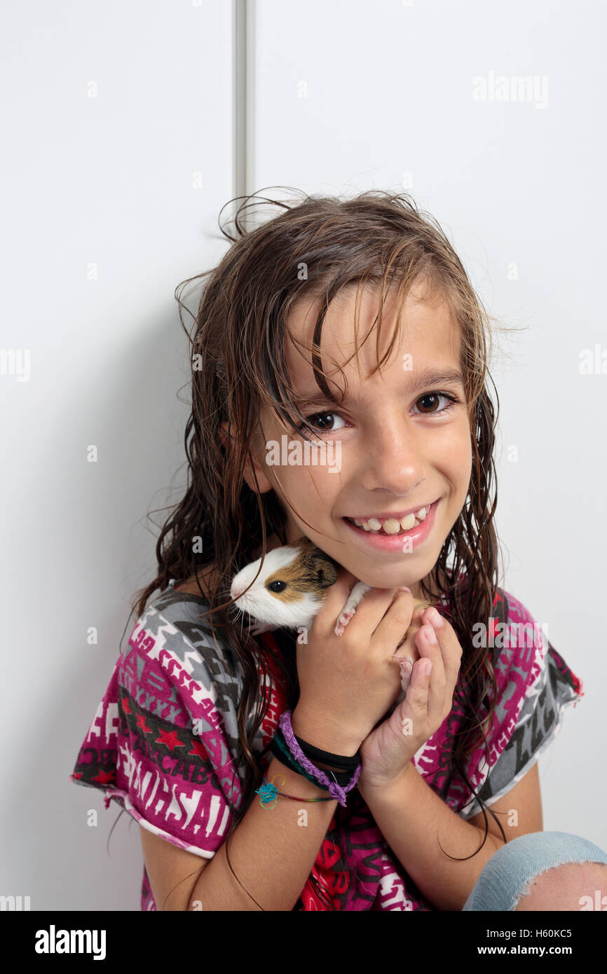Fille heureux avec votre cobaye dans les mains. Prendre à la verticale, avec la lumière de lin dans l'intérieur. Banque D'Images