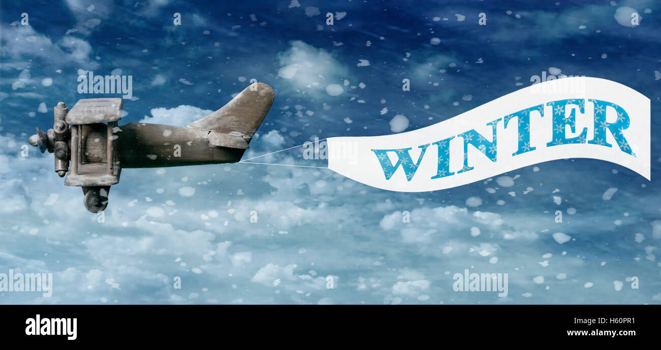 Vintage jouet en bois avion tirant une bannière d'hiver dans la neige ciel rempli Banque D'Images Vintage jouet en bois avion tirant une bannière d'hiver dans la neige ciel rempli Banque D'Images