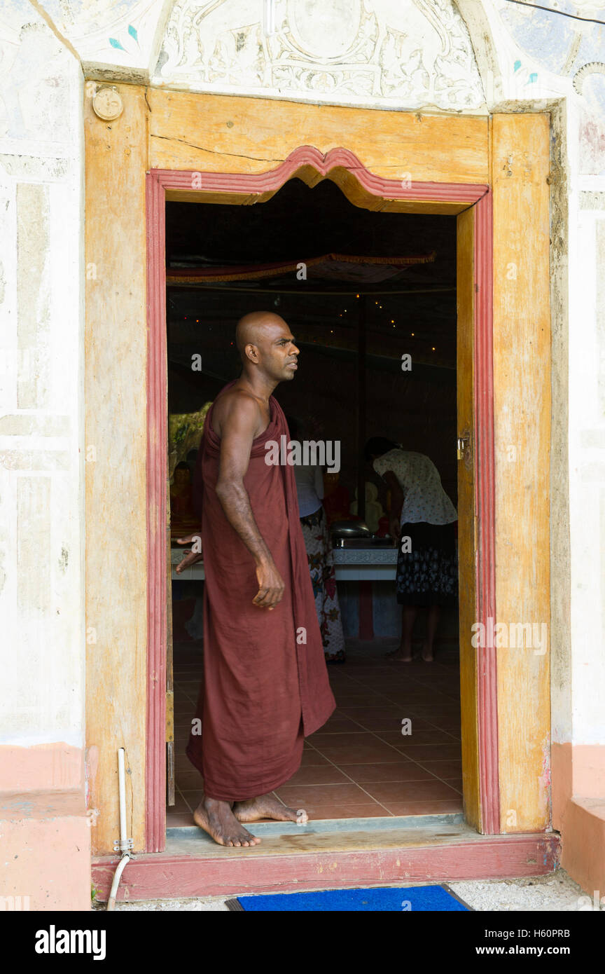 Moine à l'entrée d'Rakkhiththa kanda cave temple, Ella, Sri Lanka Banque D'Images