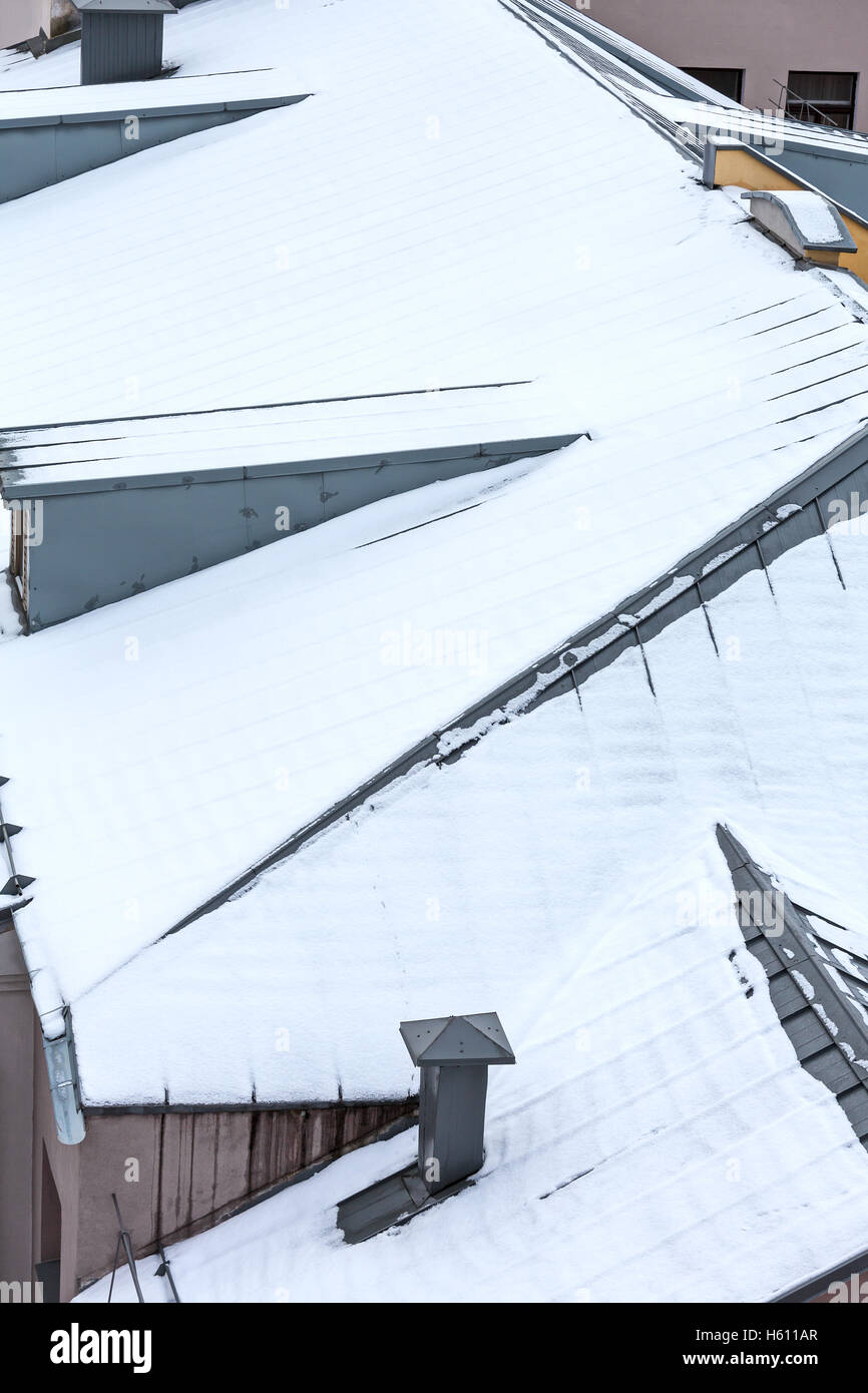 Toit en métal gris recouvert de neige avec cheminée et les lucarnes Banque D'Images