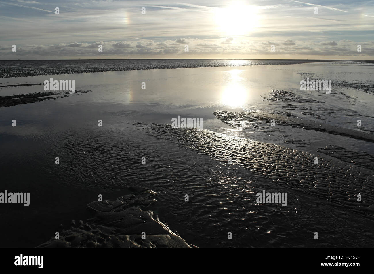 Traversée du canal d'eau de mer à marée basse étendue plage de sable blanc à l'horizon sun naufrage stratocumulus, Fairhaven, Lytham, UK Banque D'Images