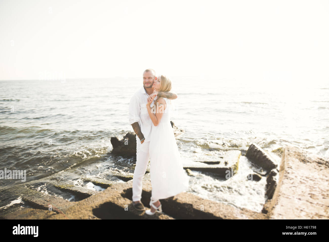 Les jeunes mariés heureux juste couples célébrant de mariage et vous amuser au belle plage coucher du soleil Banque D'Images