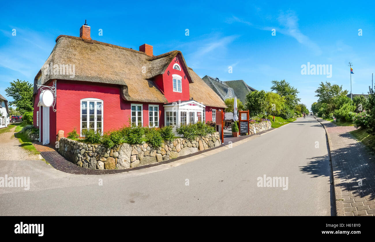 Belle maison au toit de chaume traditionnel et idyllique dans un village typique de la mer du nord allemande lors d'une journée ensoleillée en été, Mer du Nord, de l'Europe Banque D'Images