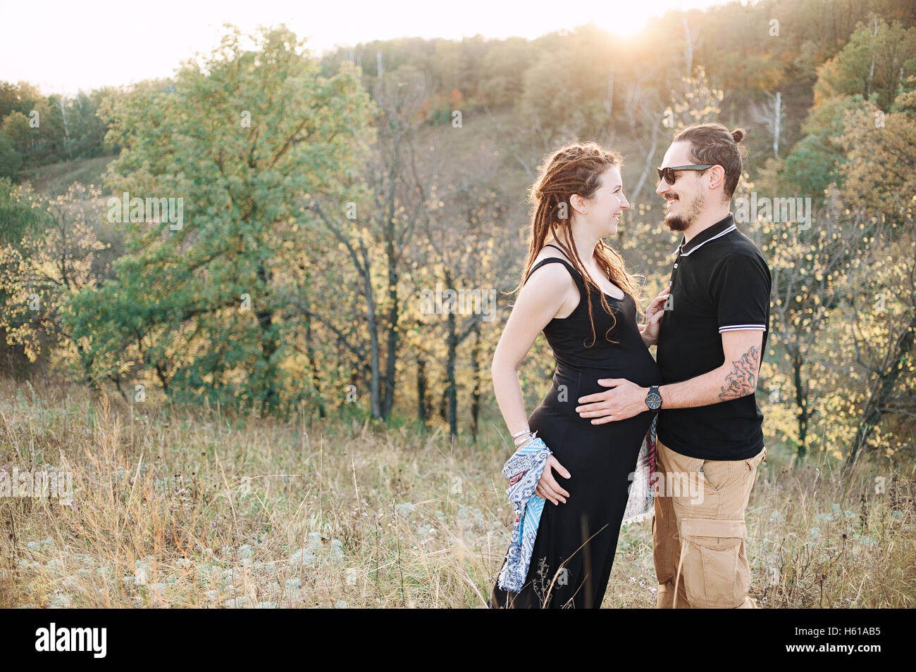 Homme et femme enceinte hugging tenant la main sur le fond de la nature sauvage, l'histoire d'amour l'automne. Banque D'Images