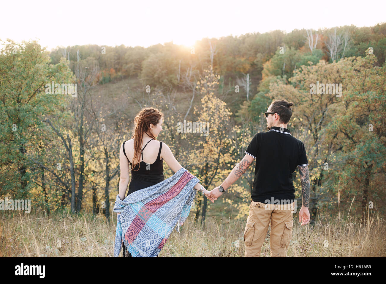 Homme et femme enceinte hugging tenant la main sur le fond de la nature sauvage, l'histoire d'amour l'automne. Banque D'Images