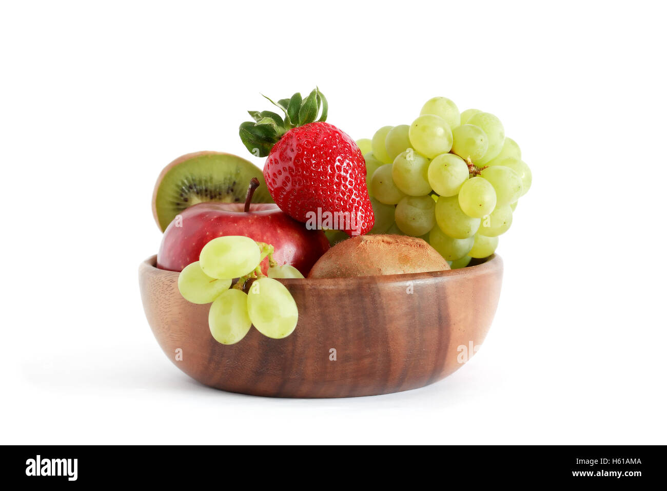 Joli bol en bois plein de divers fruits sur fond blanc Banque D'Images