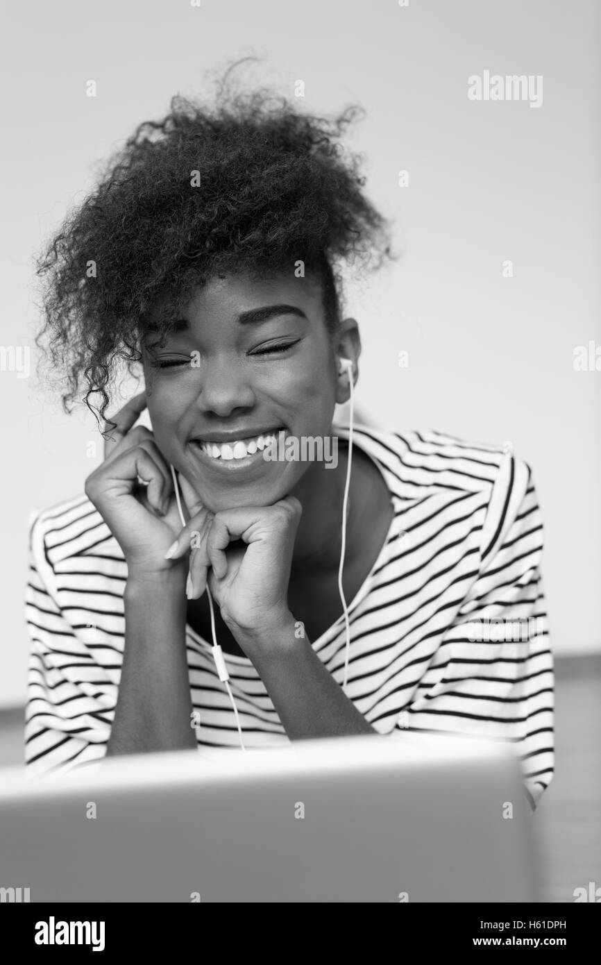 African American Woman en utilisant un ordinateur portable dans sa salle de séjour Banque D'Images