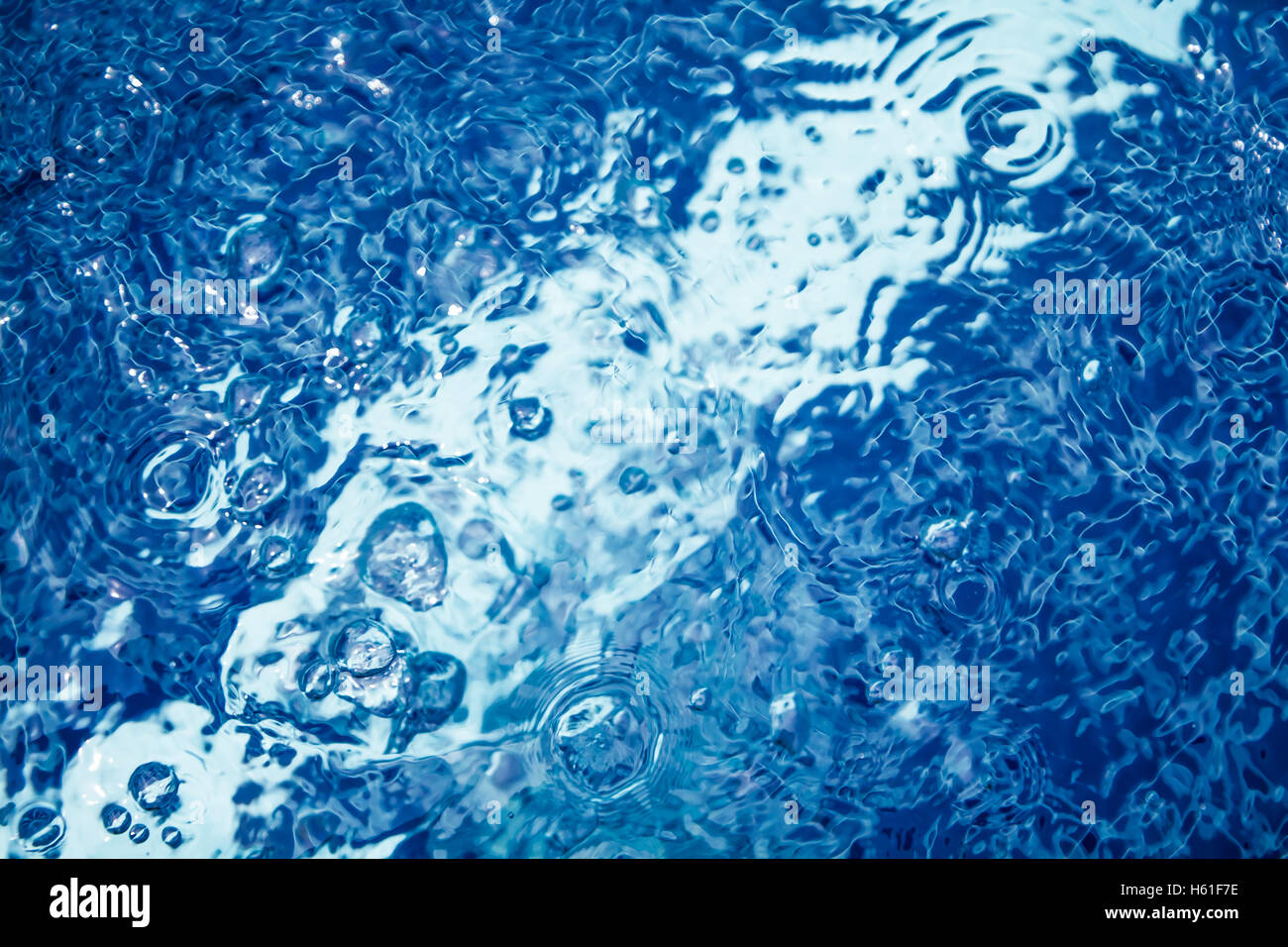 Surface de l'eau transparente en piscine avec des bulles et de rides Banque D'Images