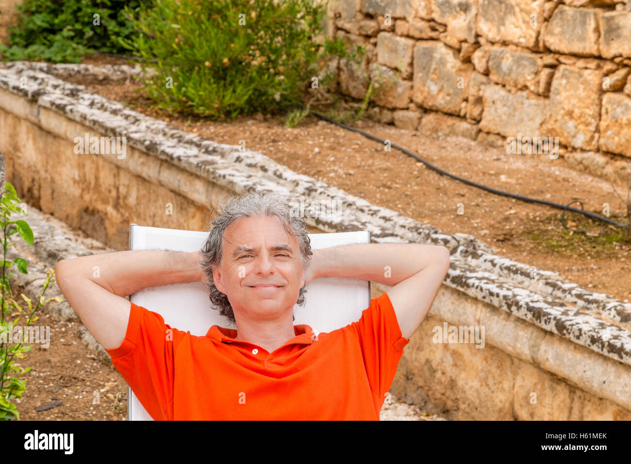 Cadre supérieur retraité man resting blissfully allongé sur la chaise longue  dans le jardin Photo Stock - Alamy