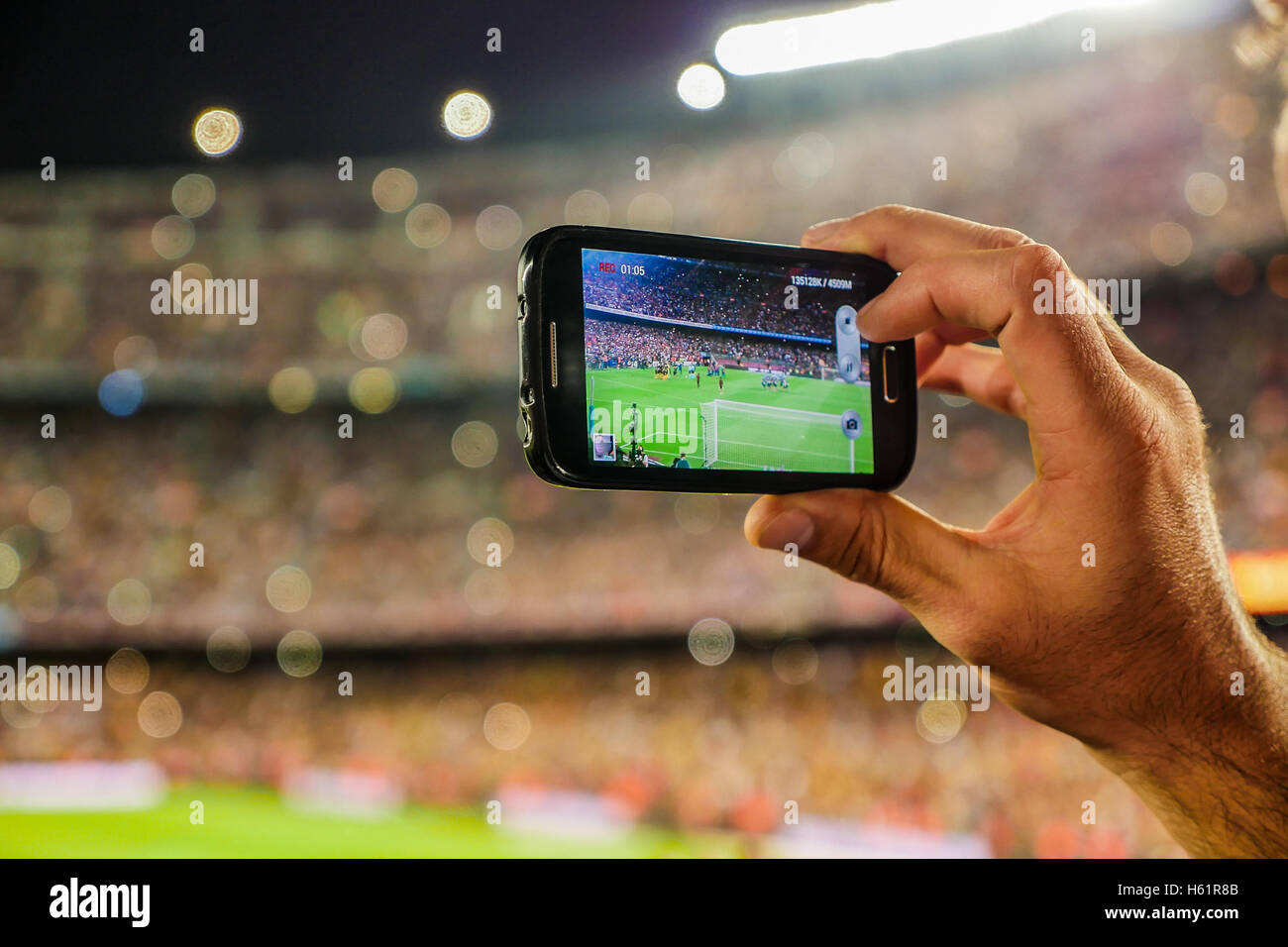 Un partisan de C.F. L'équipe de football de Barcelone, l'enregistrement d'un but avec son téléphone portable appareil photo vers le Camp Nou, Barcelona, S Banque D'Images