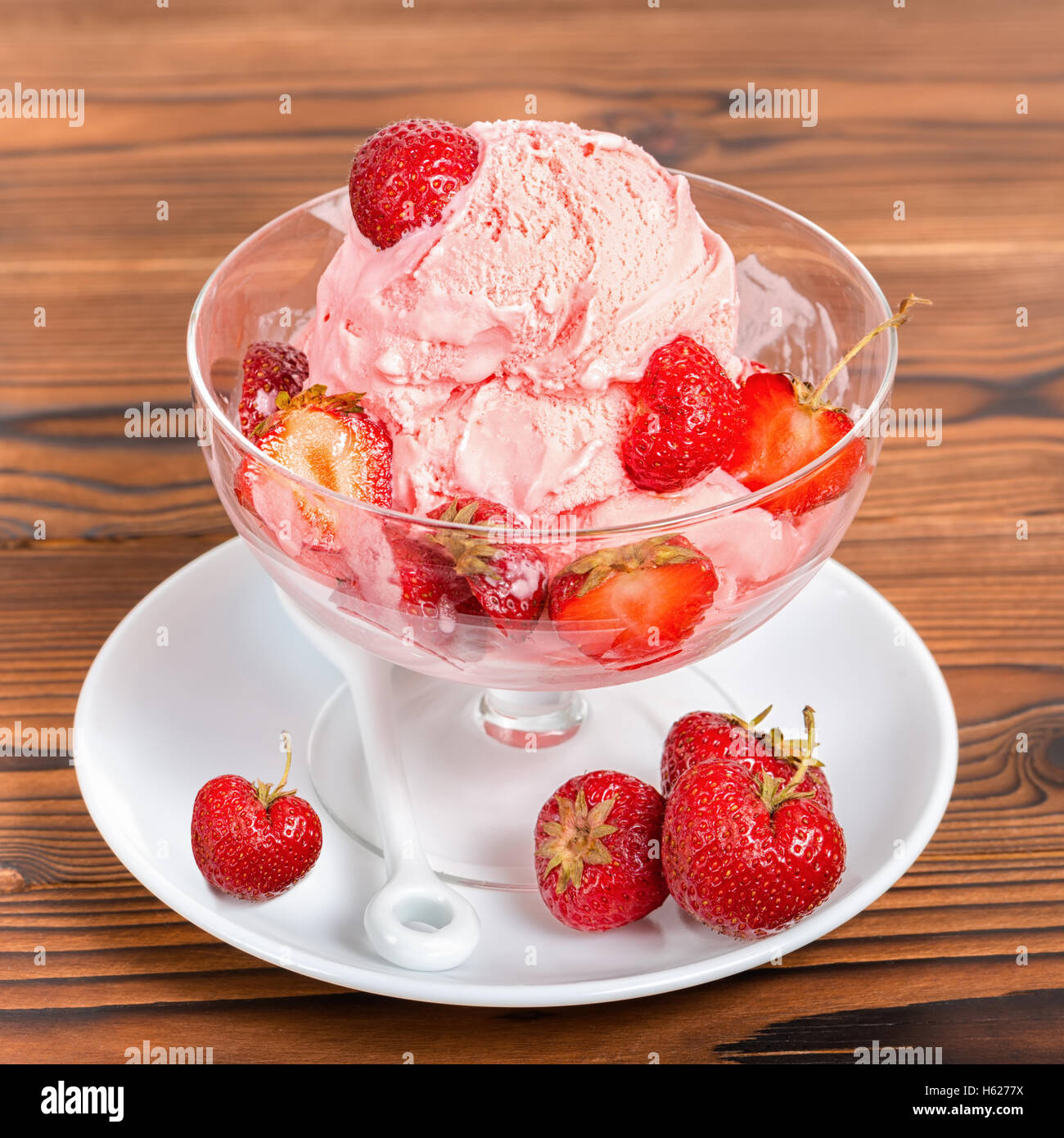 Délicieux dessert fraise vanille rose boules de glace avec des fraises fraîches dans un bol sur fond de bois, Close up Banque D'Images
