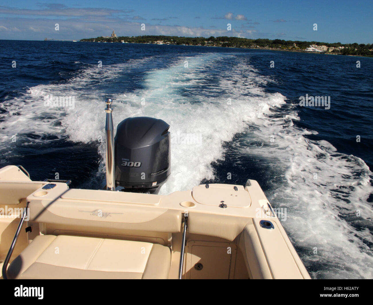Arrière d'un bateau de vitesse laissant les côtes de la Barbade en vitesse propulsé par un moteur hors-bord Banque D'Images