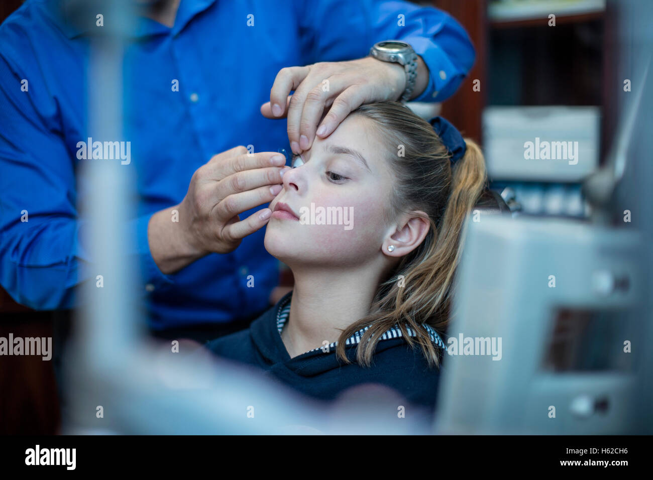 L'insertion d'un optométriste en lentilles de contact des yeux de la jeune fille Banque D'Images