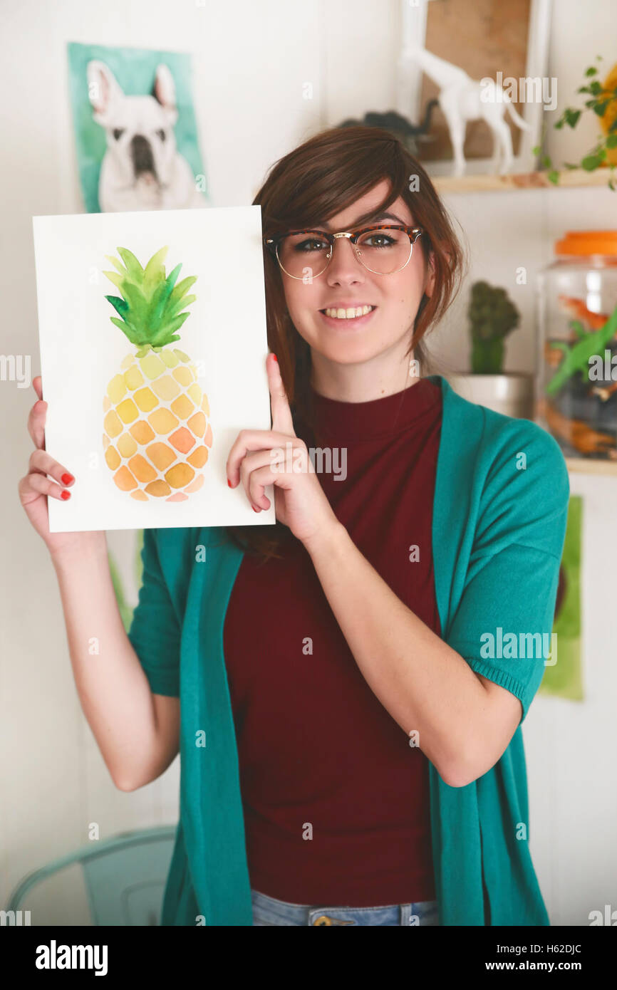 Portrait of smiling artiste montrant son aquarelle d'un ananas Banque D'Images