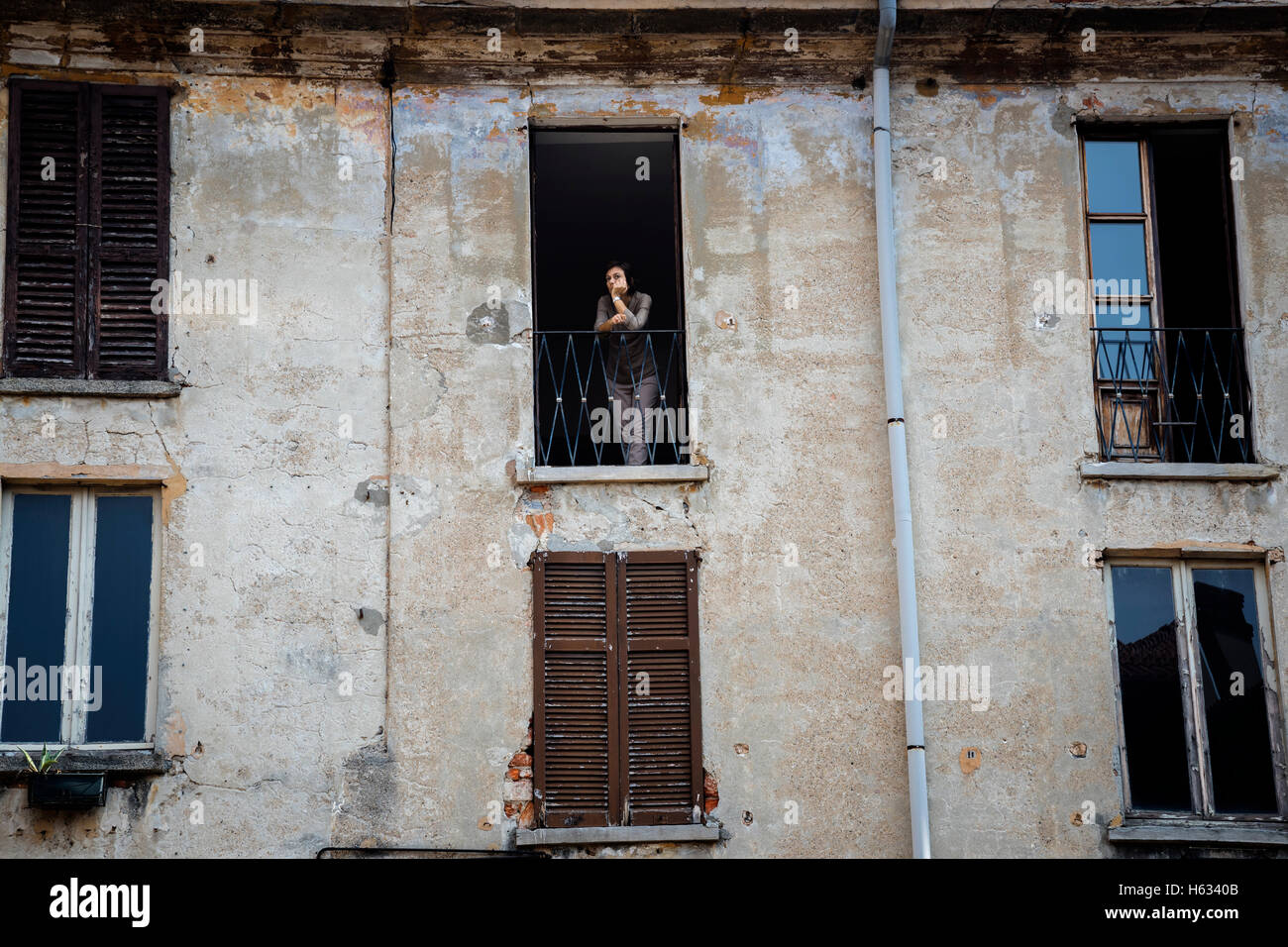 Femme regardant par la fenêtre de l'ancienne maison, Côme, l'extrémité sud du lac de Côme, Italie du nord, en Europe Banque D'Images