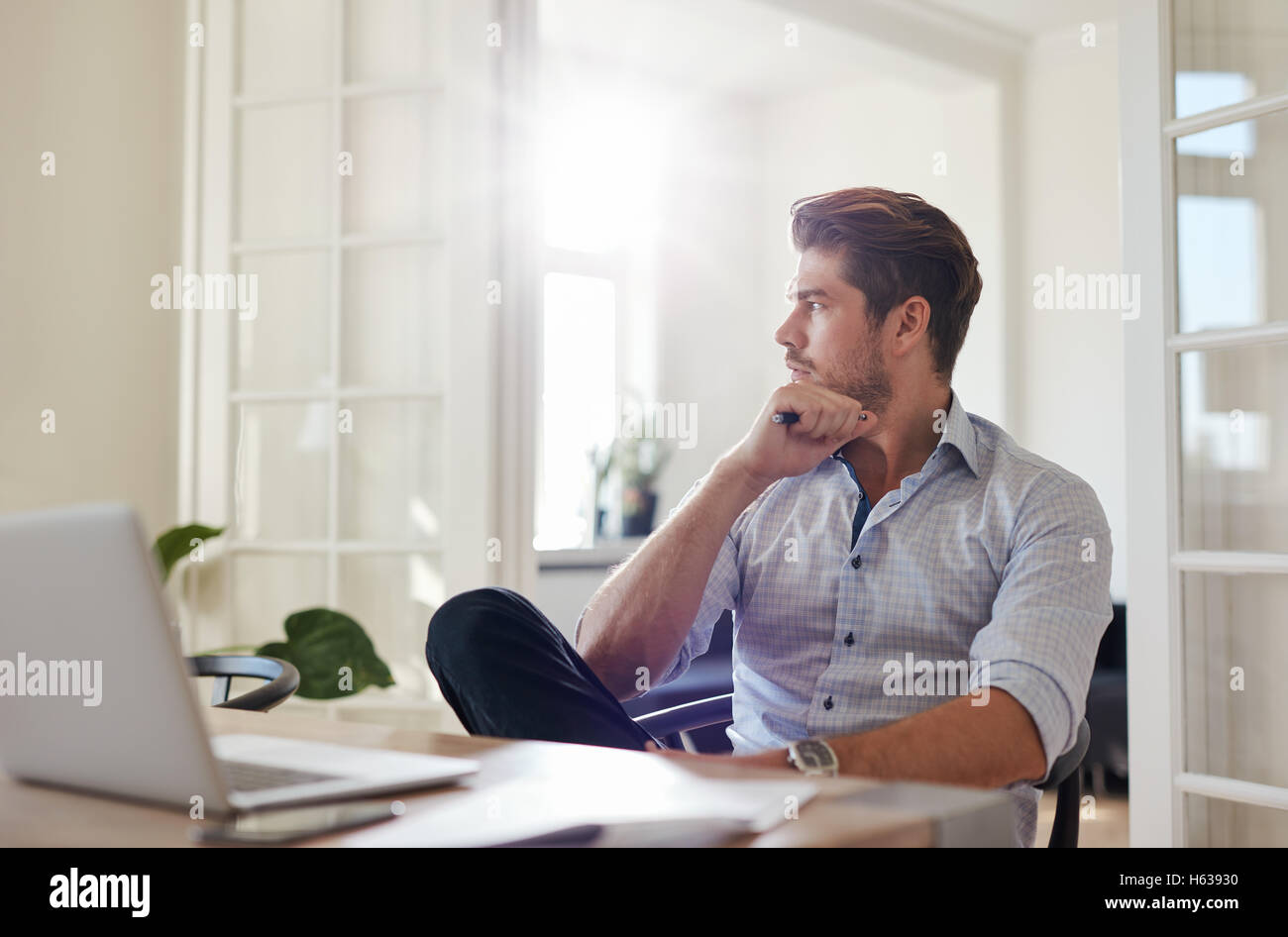 Shot of young man sitting at table à l'écart et la pensée. Thoughtful woman home office. Banque D'Images