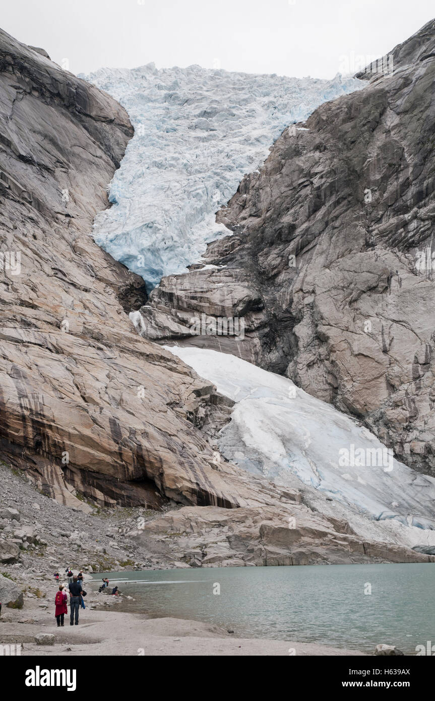 Les touristes d'admirer le Glacier Briksdal par la lagune de fonte, Briksdalen valley, le parc national de Jostedalsbreen, la Norvège. Banque D'Images