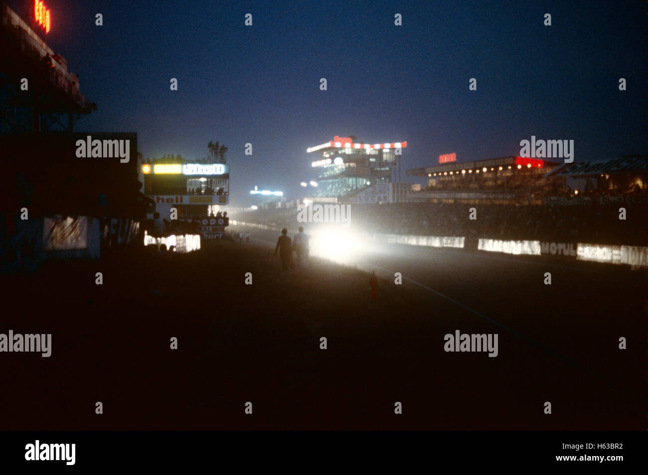 Phares d'une voiture de course le début ligne droite dans la nuit au Mans 1980 Banque D'Images