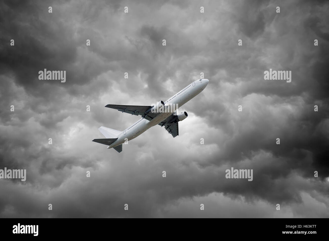 Avion décolle sous des nuages gris Banque D'Images