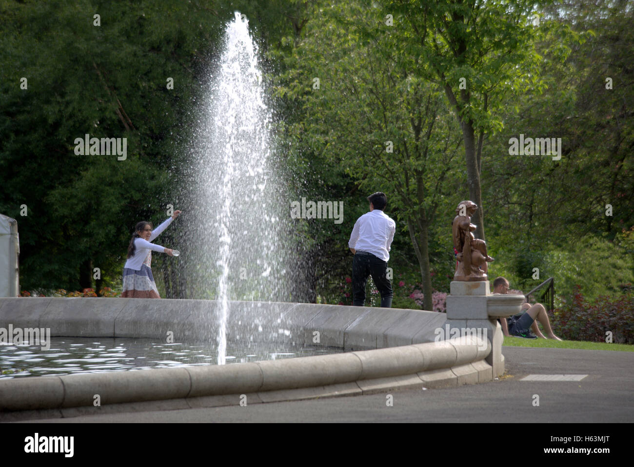 Les asiatiques jouant avec stewart Glasgow fontaine du parc Kelvingrove qui contient à la fois l'université le musée dans la zone du parc Banque D'Images