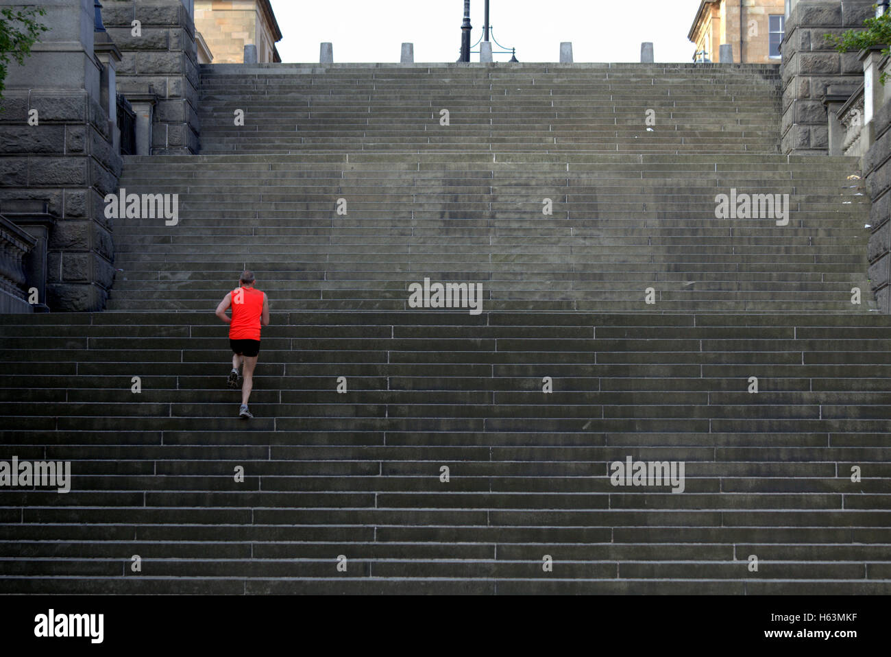 Homme runner courir vers le haut les étapes park circus domaine de Glasgow Banque D'Images