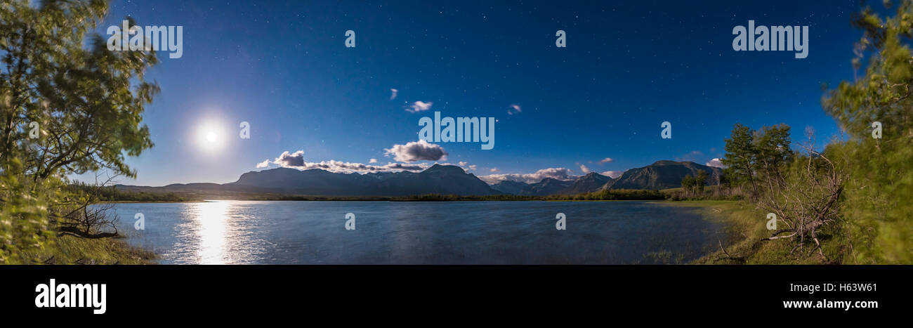 Clair de lune, sur l'étang maskinongé dans le parc national des Lacs-Waterton, en Alberta, avec une presque pleine lune sur l'étang, et d'un bleu profond de mo Banque D'Images