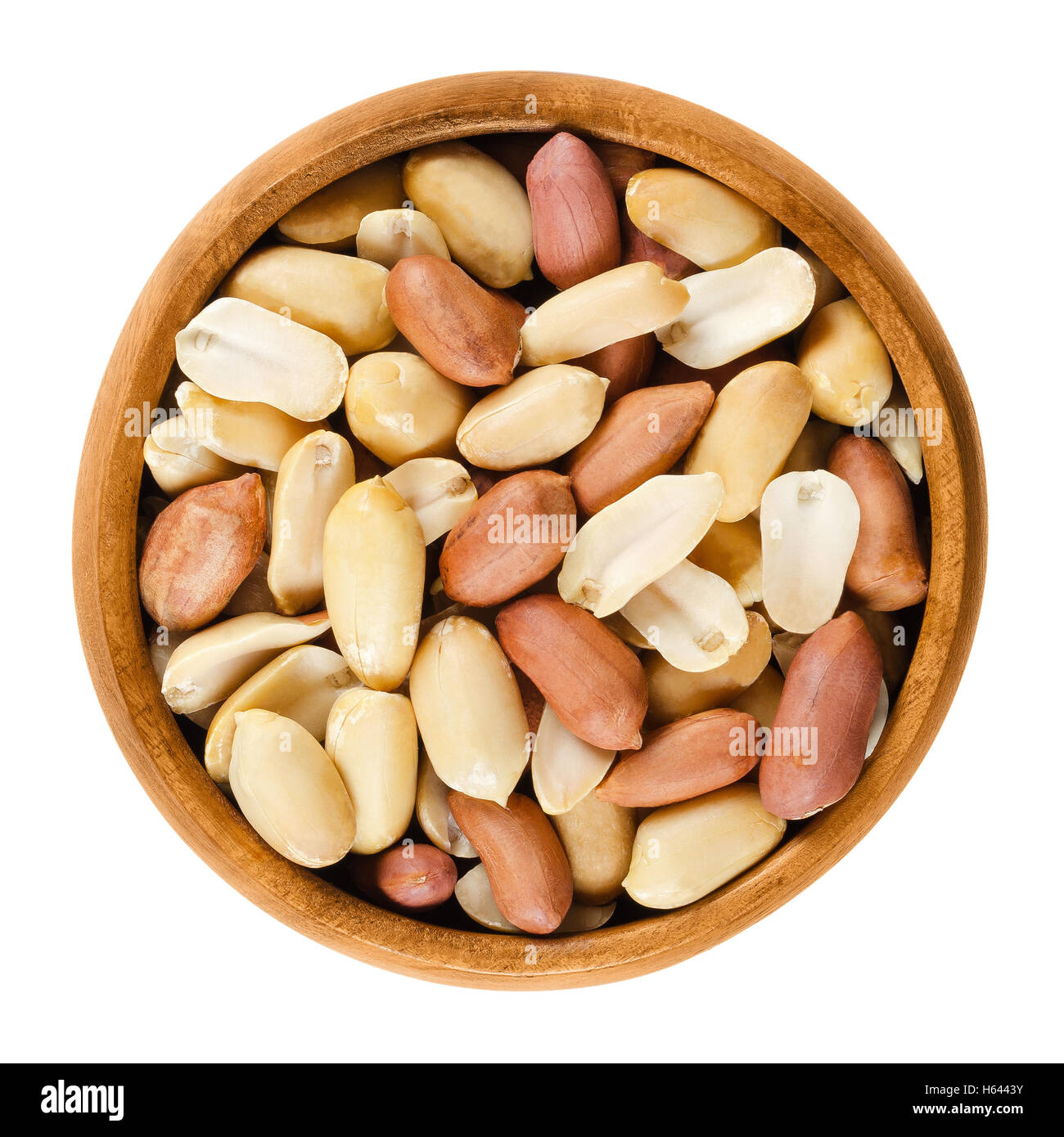 Arachides décortiquées dans bol en bois sur fond blanc. L'Arachis hypogaea rôties à sec, aussi appelé l'arachide et goober. Banque D'Images