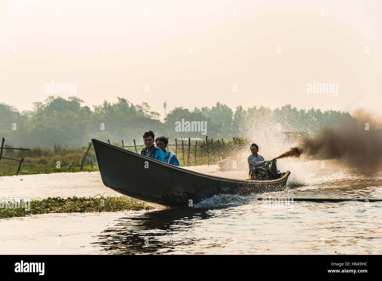 Sections locales sur motor yacht en bois foncé avec de la fumée, au Lac Inle, à l'État de Shan, Myanmar Banque D'Images