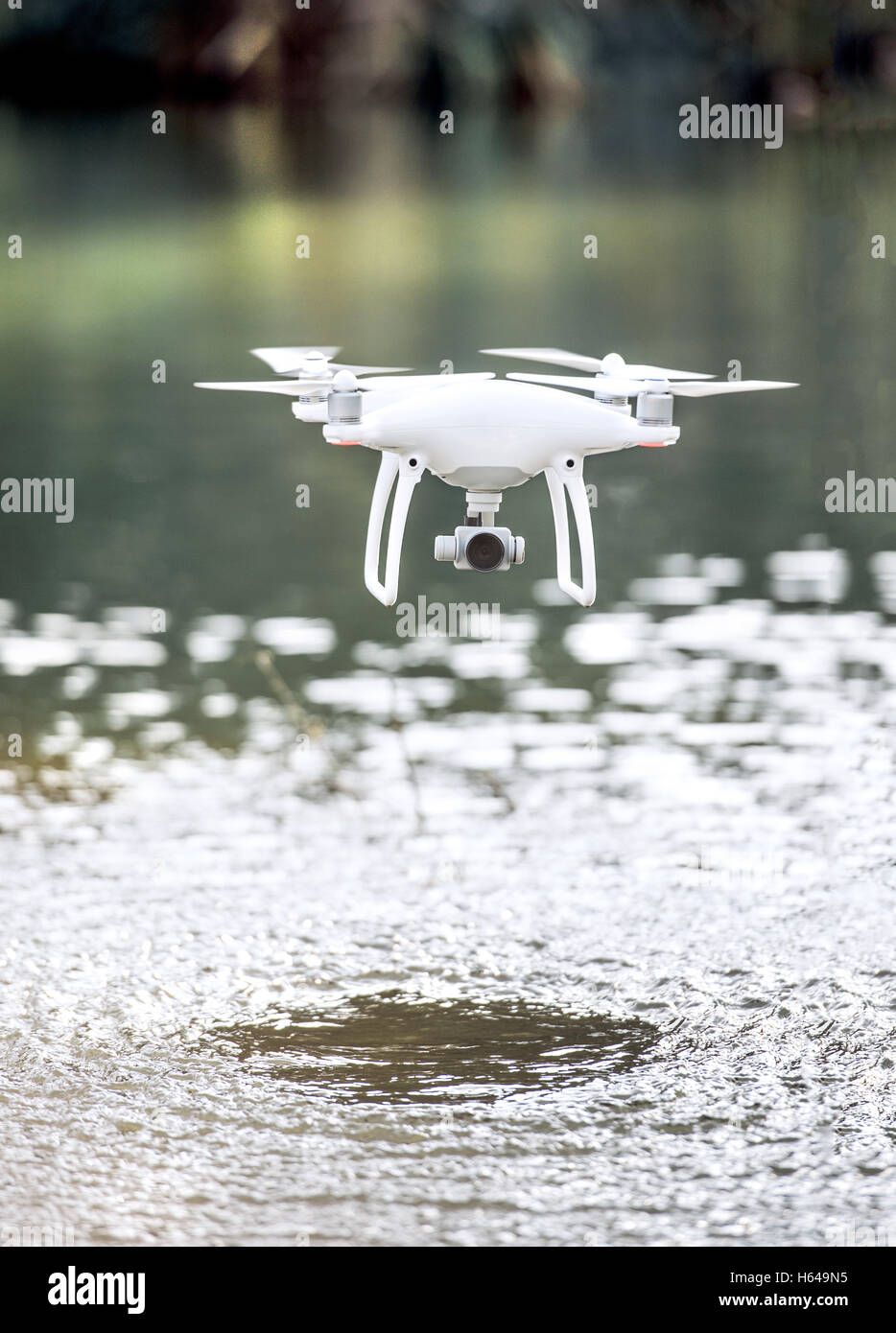 Drone quadcopter, avec un appareil volant au-dessus de l'eau. Banque D'Images