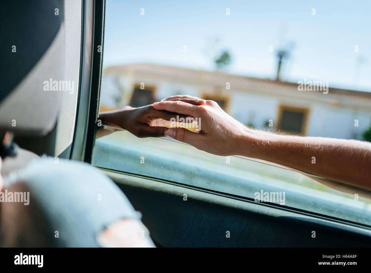 Deux mains liées par la fenêtre d'une voiture Banque D'Images