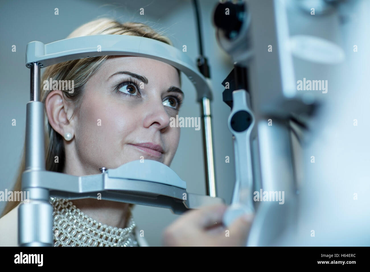 Femme mature faire l'essai d'oeil à l'optométriste. Banque D'Images