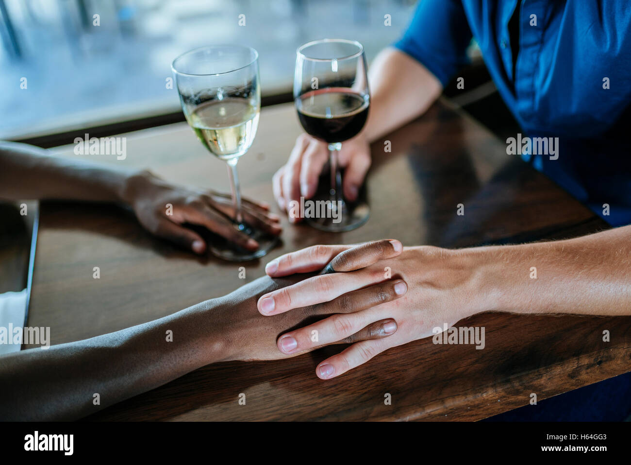 Close-up of a couple holding hands in restaurant Banque D'Images
