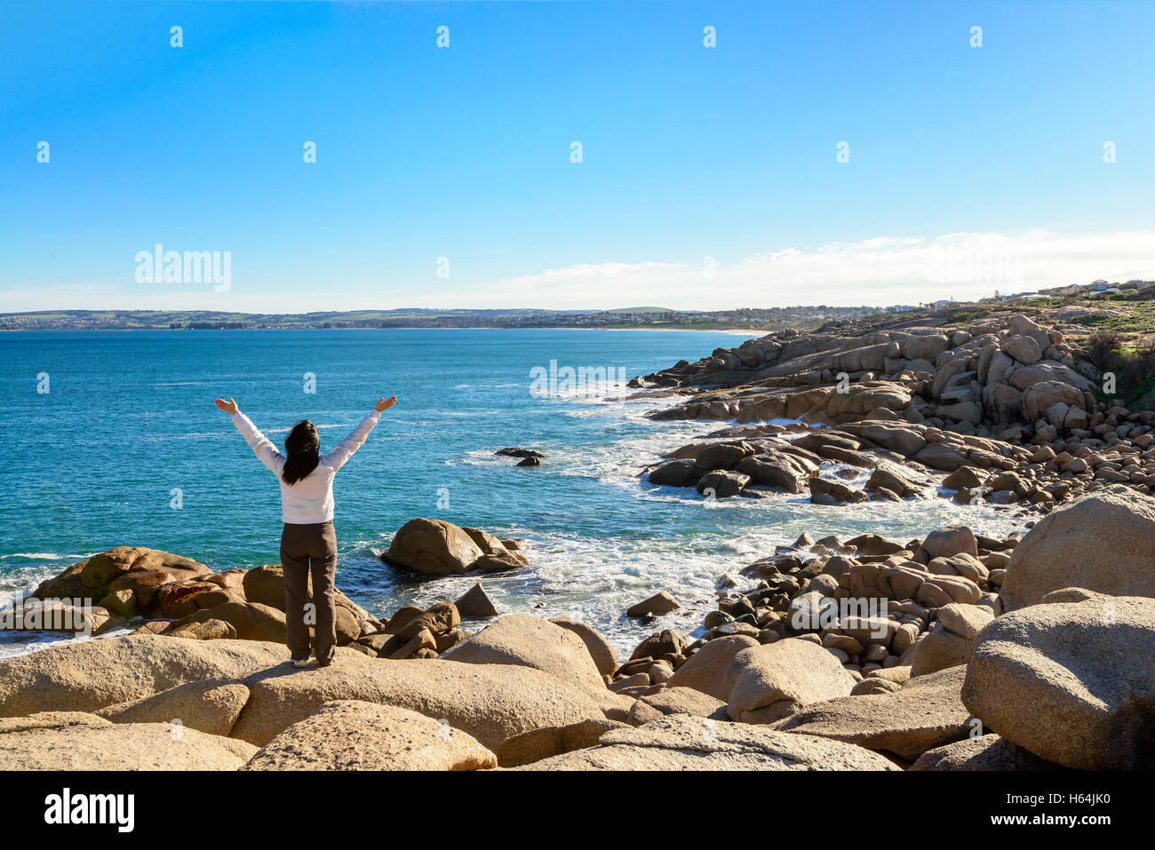 Femme debout au bord du rocher et à la recherche dans la mer à Port Elliot, l'Australie du Sud Banque D'Images