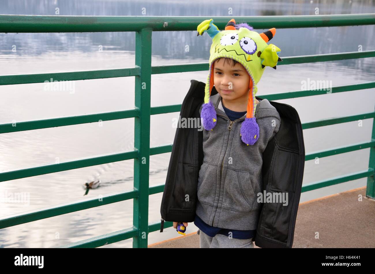 Jeune garçon à marcher le long de la rivière d'hiver. Banque D'Images