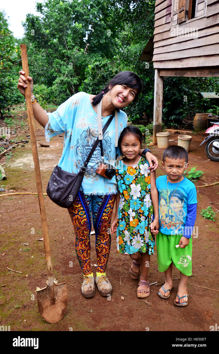 Les thaïlandais visiter et prendre des photos avec les enfants laotiens à l'extérieur de la maison locale au Plateau des Bolavens le 2 mai 2015 à Paksong, C Banque D'Images