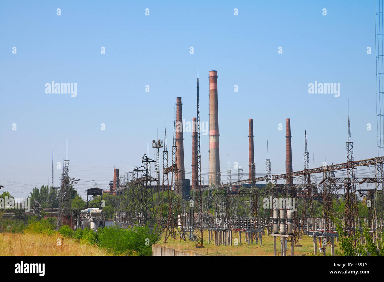 Zone Industrielle, prend en charge à haute tension et cheminées Banque D'Images