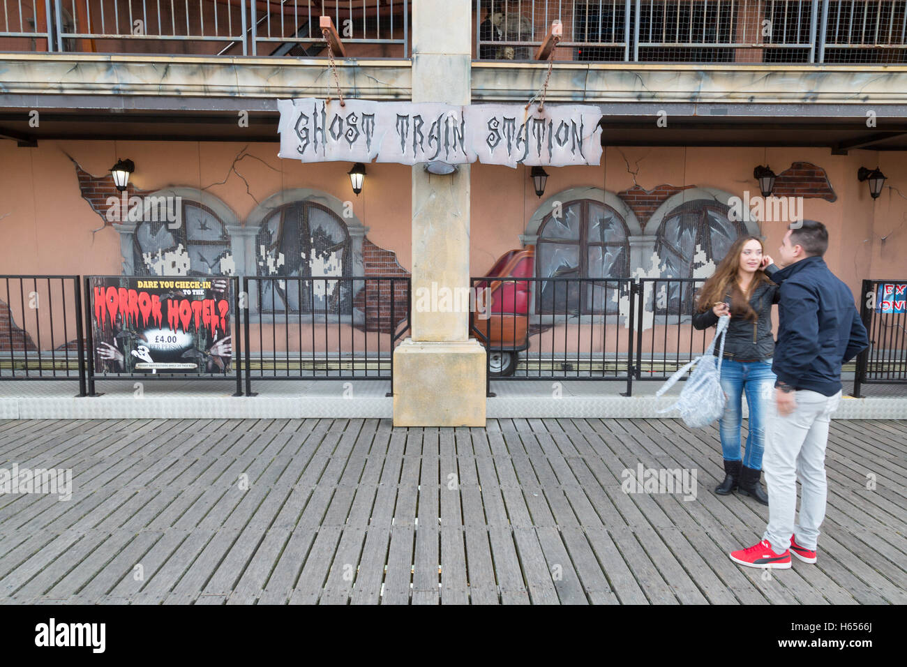 Un couple looking at the Ghost Train ride, jetée de Brighton, Brighton, East Sussex England UK Banque D'Images