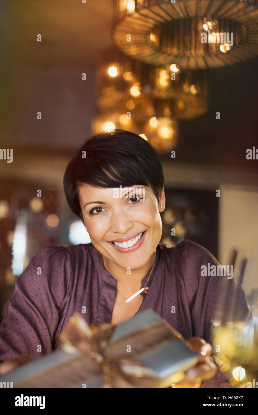 Portrait of smiling woman giving gift Banque D'Images