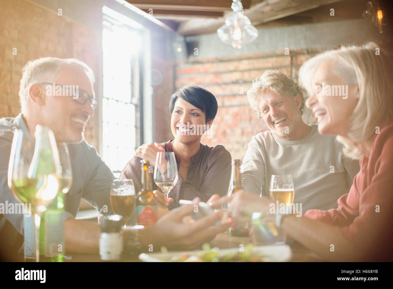 Des couples coin et using cell phone at restaurant table Banque D'Images