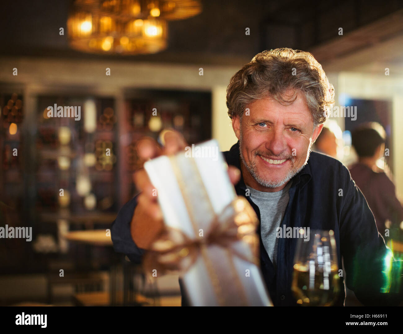 Portrait of smiling senior man giving gift en bar Banque D'Images